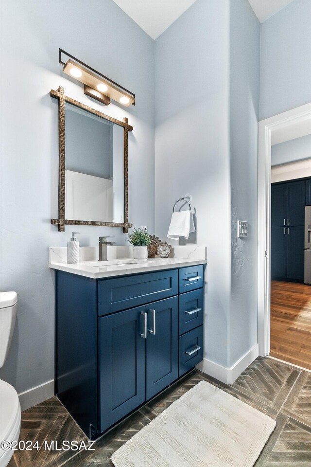 bathroom featuring vanity, toilet, and wood-type flooring