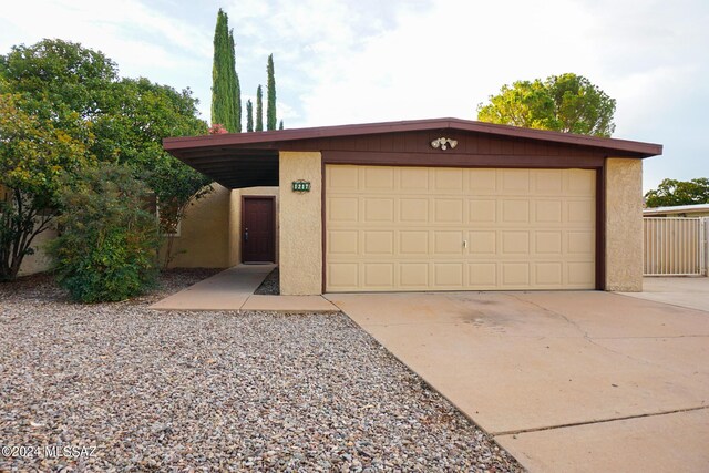 view of front of house featuring stucco siding, a garage, and driveway