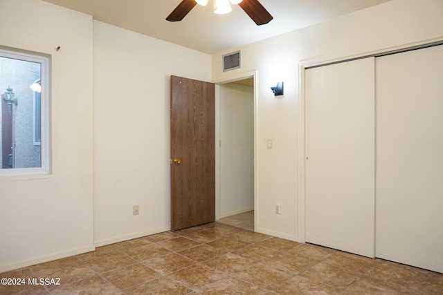 unfurnished bedroom with a ceiling fan, visible vents, a closet, and baseboards