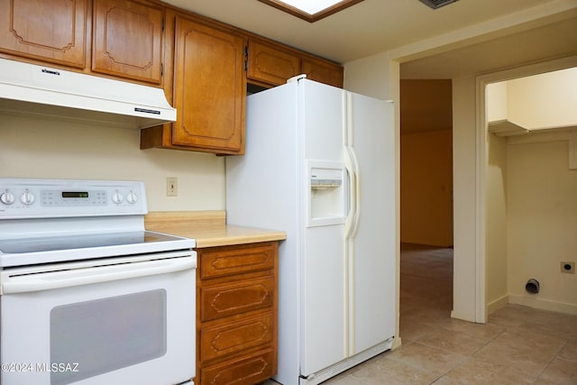 kitchen featuring baseboards, under cabinet range hood, light countertops, brown cabinetry, and white appliances