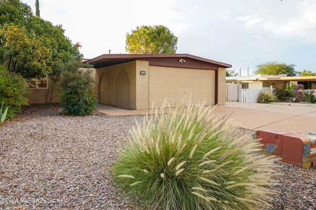 garage featuring driveway and fence