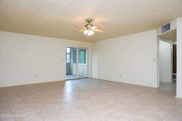 unfurnished room with light tile patterned floors, visible vents, baseboards, and a ceiling fan