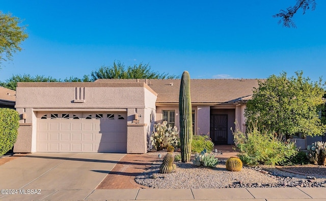 view of front of house featuring a tile roof, stucco siding, a garage, and concrete driveway