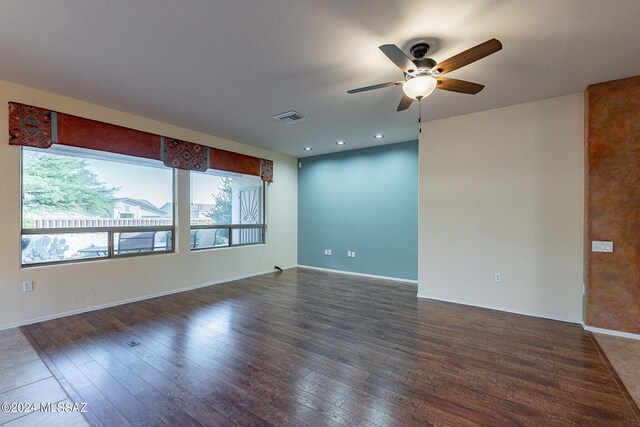 spare room featuring ceiling fan and dark wood-type flooring