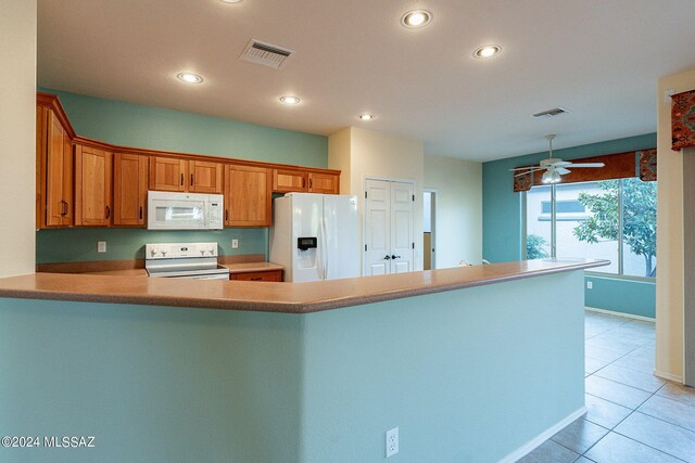 kitchen featuring kitchen peninsula, white appliances, ceiling fan, and light tile patterned flooring