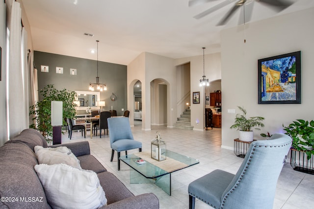 living room with light tile patterned flooring and ceiling fan with notable chandelier