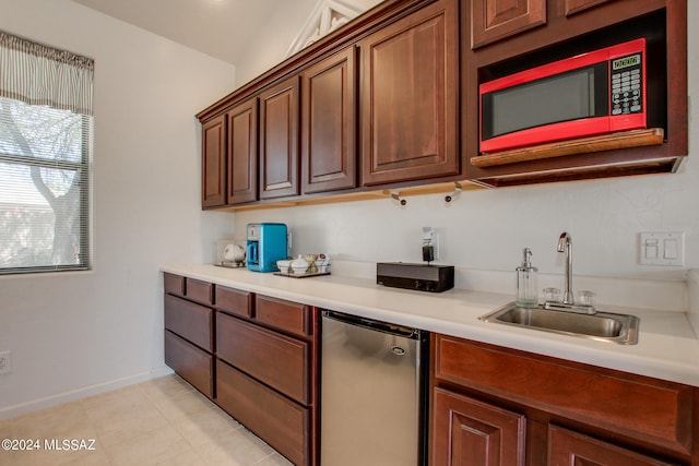 kitchen with sink, stainless steel fridge, vaulted ceiling, and light tile patterned floors