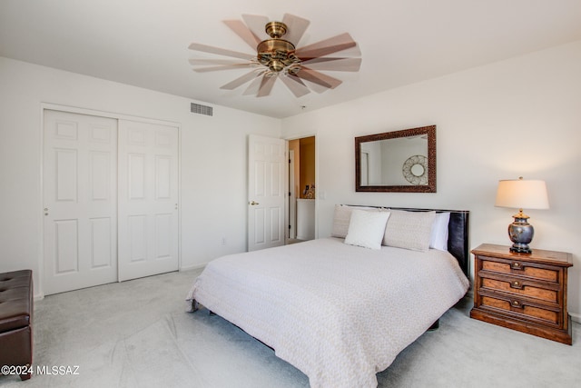 bedroom with a closet, ceiling fan, and light colored carpet