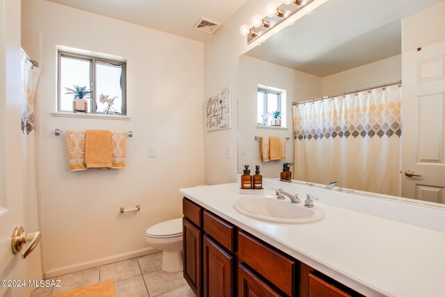 bathroom with toilet, vanity, and tile patterned floors