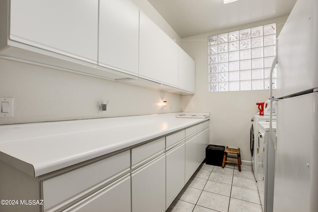 laundry room with cabinets, washer and clothes dryer, and light tile patterned floors