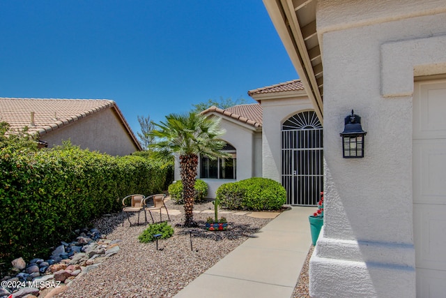 view of exterior entry with a patio area