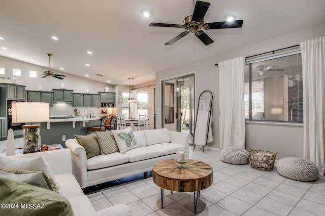 living room featuring lofted ceiling, ceiling fan, and light tile patterned floors