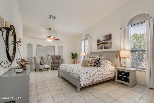 bedroom featuring lofted ceiling, light tile patterned floors, and ceiling fan