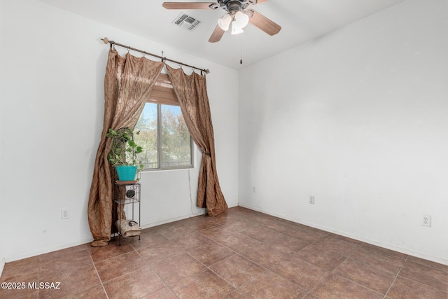 spare room with baseboards, ceiling fan, and visible vents