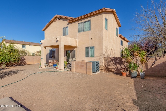 back of property featuring central air condition unit, stucco siding, a fenced backyard, a tiled roof, and a patio