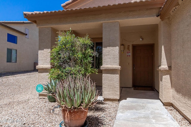view of exterior entry with stucco siding
