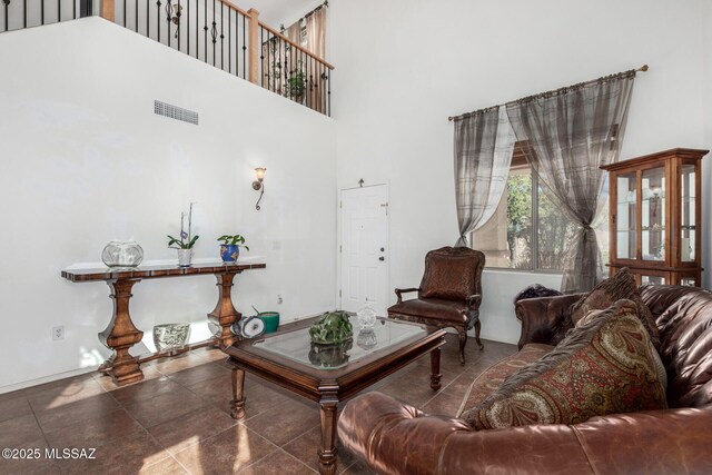 tiled living room featuring high vaulted ceiling and an inviting chandelier