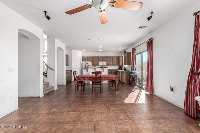tiled dining space with visible vents, ceiling fan, recessed lighting, stairway, and arched walkways