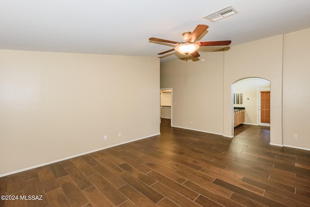 empty room with ceiling fan, dark hardwood / wood-style flooring, and high vaulted ceiling