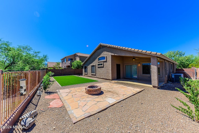 back of house with central AC unit, a fire pit, ceiling fan, and a patio area