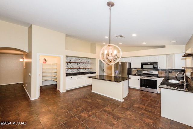 kitchen featuring sink, a center island, tasteful backsplash, decorative light fixtures, and appliances with stainless steel finishes