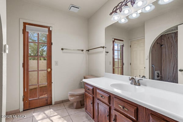 bathroom featuring vanity, tile patterned floors, and toilet