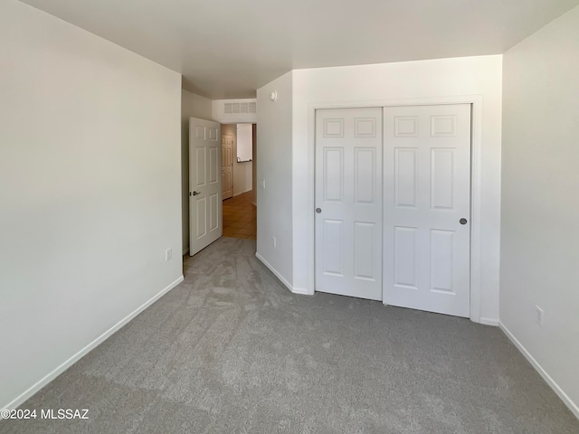 unfurnished bedroom with a closet and carpet