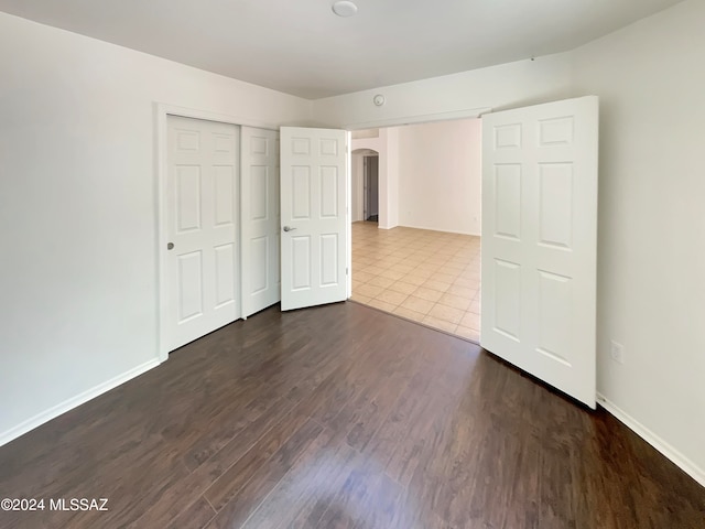 unfurnished bedroom featuring hardwood / wood-style flooring and a closet