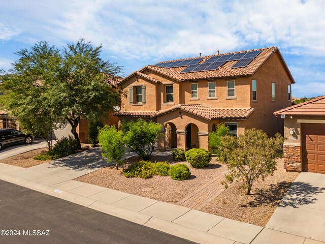 view of front of property featuring solar panels and a garage