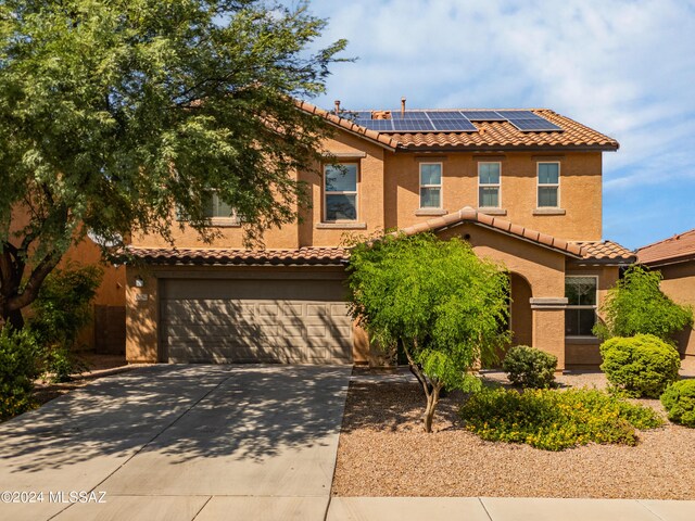 view of front facade featuring solar panels and a garage