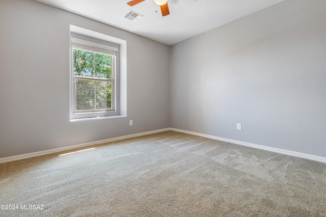 carpeted spare room featuring ceiling fan