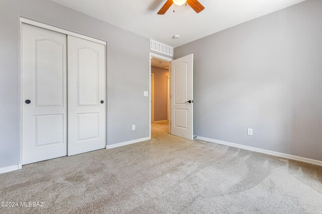 unfurnished bedroom with a closet, ceiling fan, and light carpet