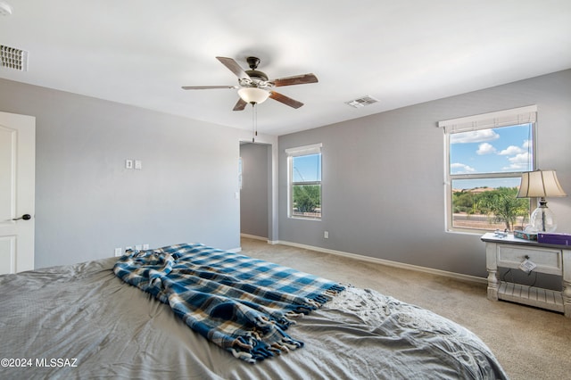 bedroom with ceiling fan and light carpet