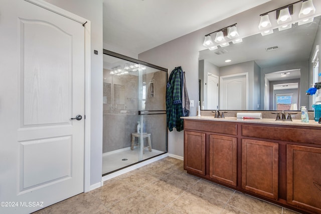 bathroom featuring tile patterned flooring, dual bowl vanity, and an enclosed shower