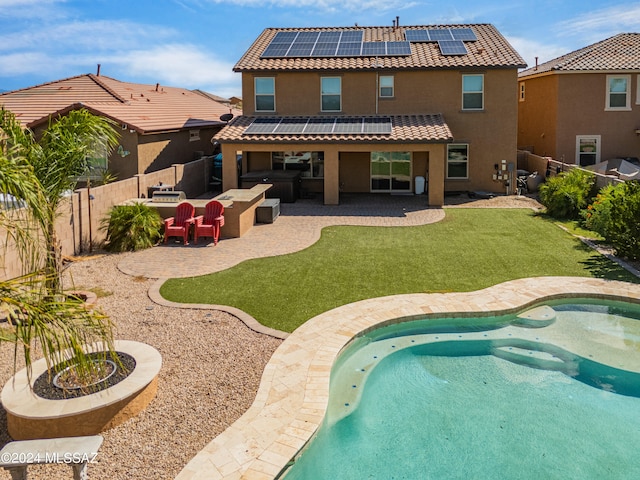 rear view of house featuring a lawn, solar panels, a fenced in pool, and a patio