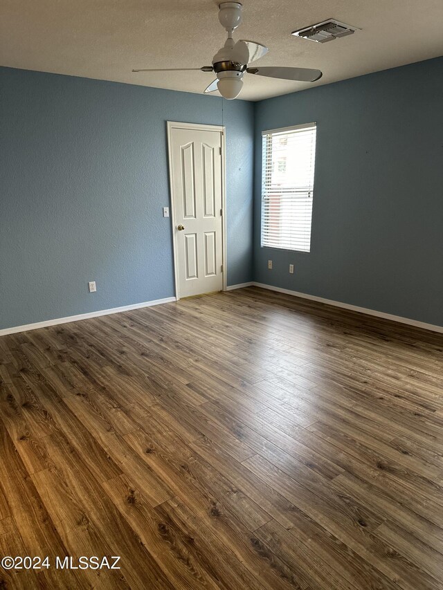 empty room with ceiling fan and dark hardwood / wood-style floors