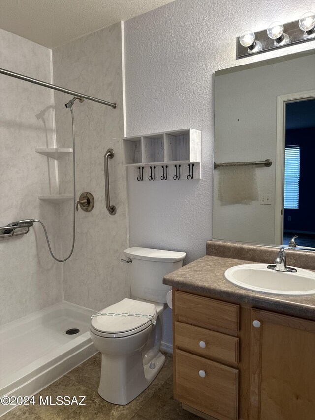 bathroom with vanity, a shower, tile patterned flooring, toilet, and a textured ceiling