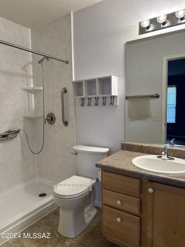 bathroom with tiled shower, vanity, toilet, and tile patterned flooring