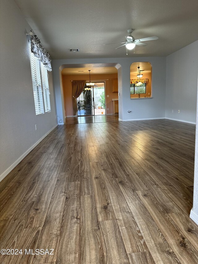 unfurnished living room featuring ceiling fan and dark hardwood / wood-style flooring