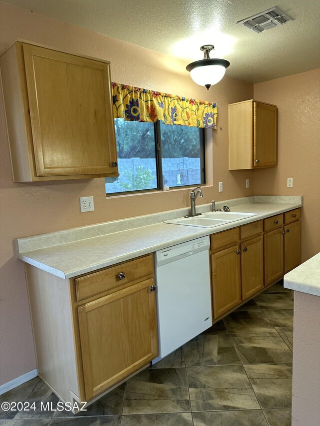 kitchen featuring dishwasher, a textured ceiling, and sink