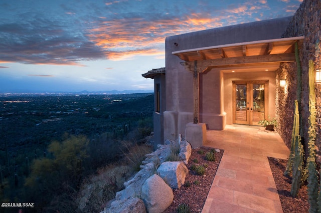 property exterior at dusk featuring french doors