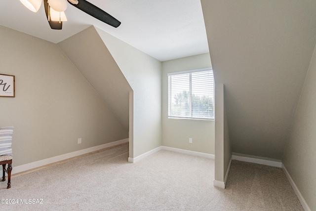 additional living space featuring light colored carpet, lofted ceiling, and ceiling fan