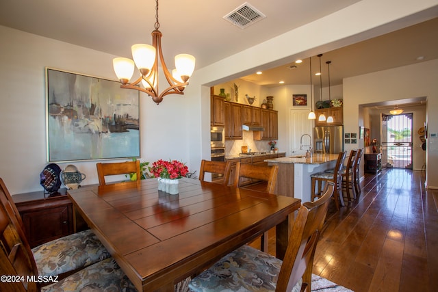 dining area featuring sink, dark hardwood / wood-style floors, and a notable chandelier