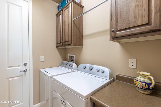 laundry area featuring washer and clothes dryer and cabinets