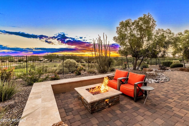 patio terrace at dusk featuring a fire pit