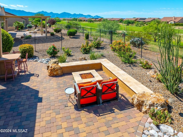 view of patio / terrace with a mountain view and an outdoor fire pit