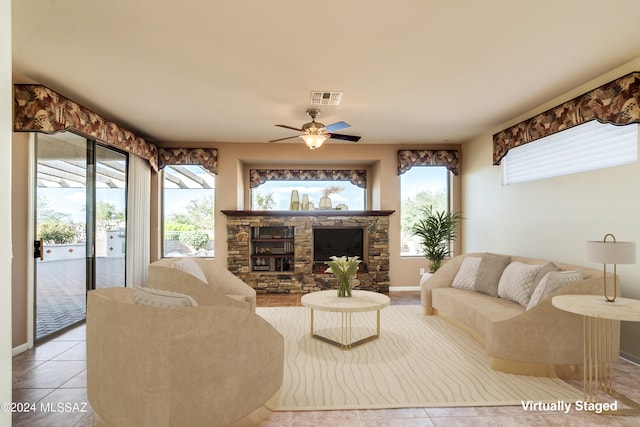 tiled living area with a ceiling fan, visible vents, plenty of natural light, and a fireplace