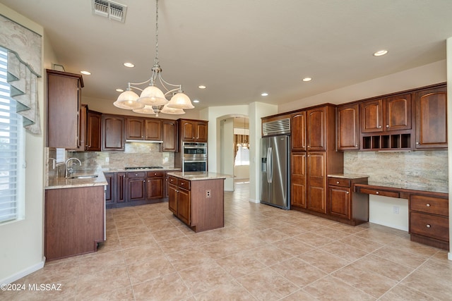 kitchen with arched walkways, visible vents, appliances with stainless steel finishes, a sink, and a chandelier