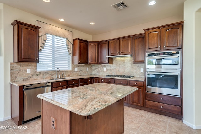 kitchen with stainless steel appliances, a sink, visible vents, light stone countertops, and tasteful backsplash