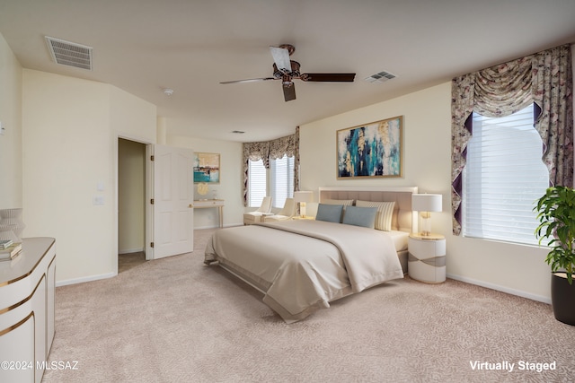 bedroom featuring baseboards, visible vents, and light colored carpet